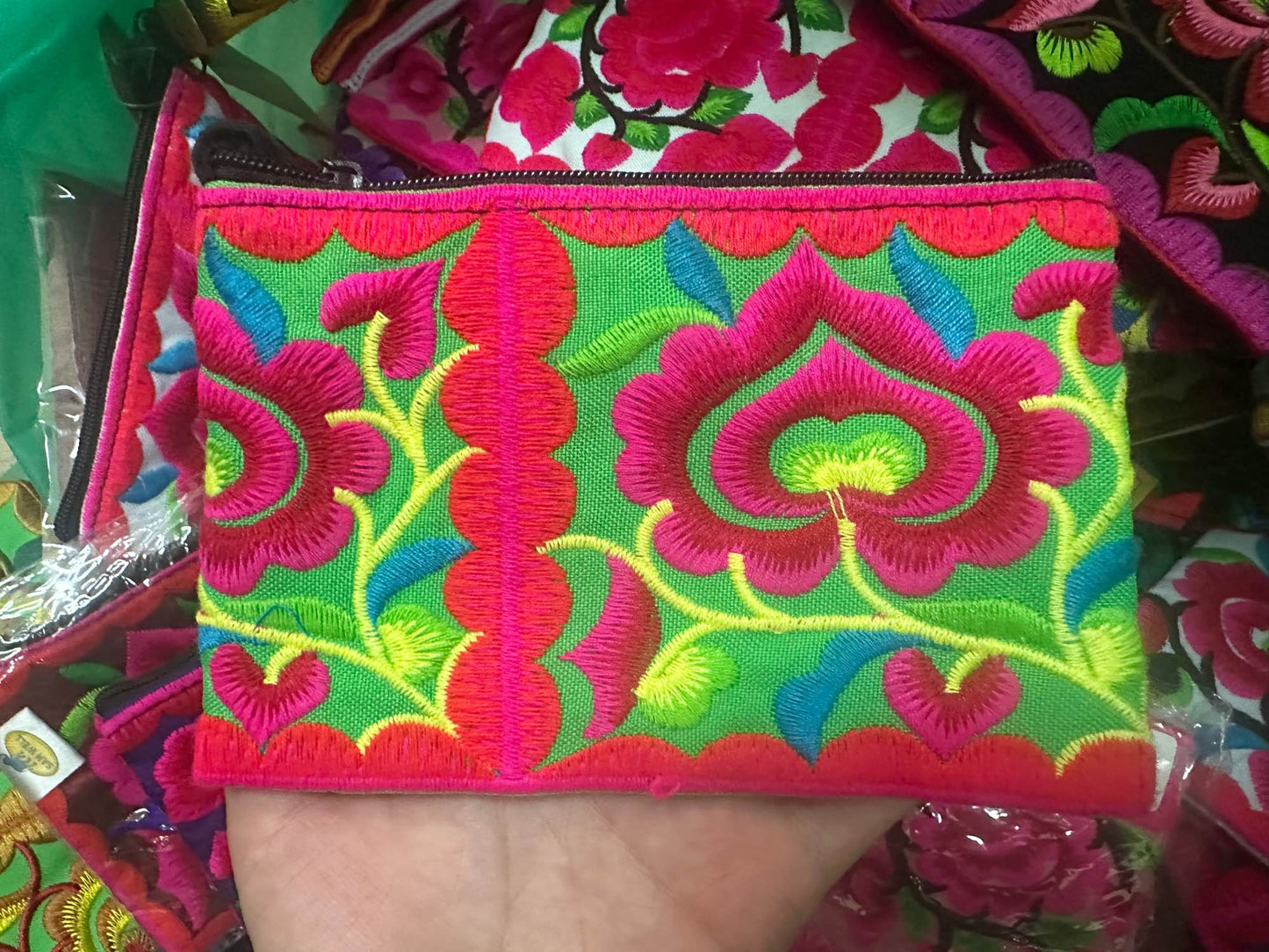 Hilltribe coin purse, embroidered, with designs on both sides. Has a wrist strap, zipper and lining. Size 4x5.5 inches.