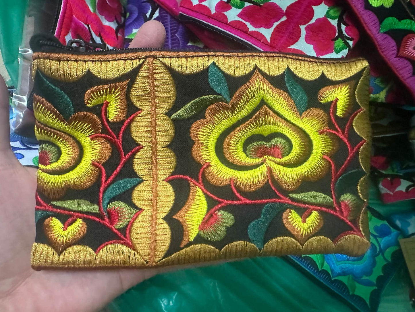 Hilltribe coin purse, embroidered, with designs on both sides. Has a wrist strap, zipper and lining. Size 4x5.5 inches.