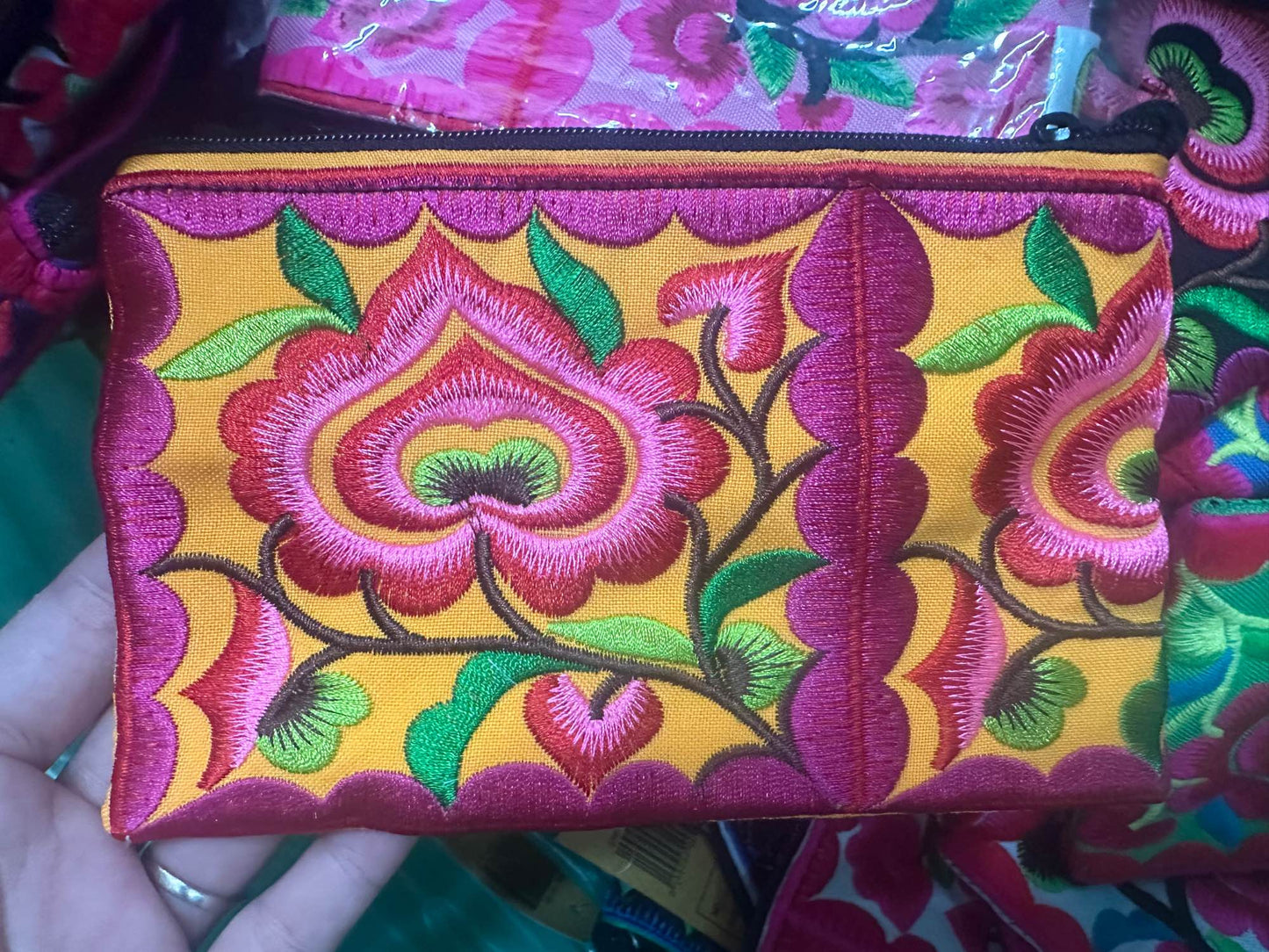 Hilltribe coin purse, embroidered, with designs on both sides. Has a wrist strap, zipper and lining. Size 4x5.5 inches.