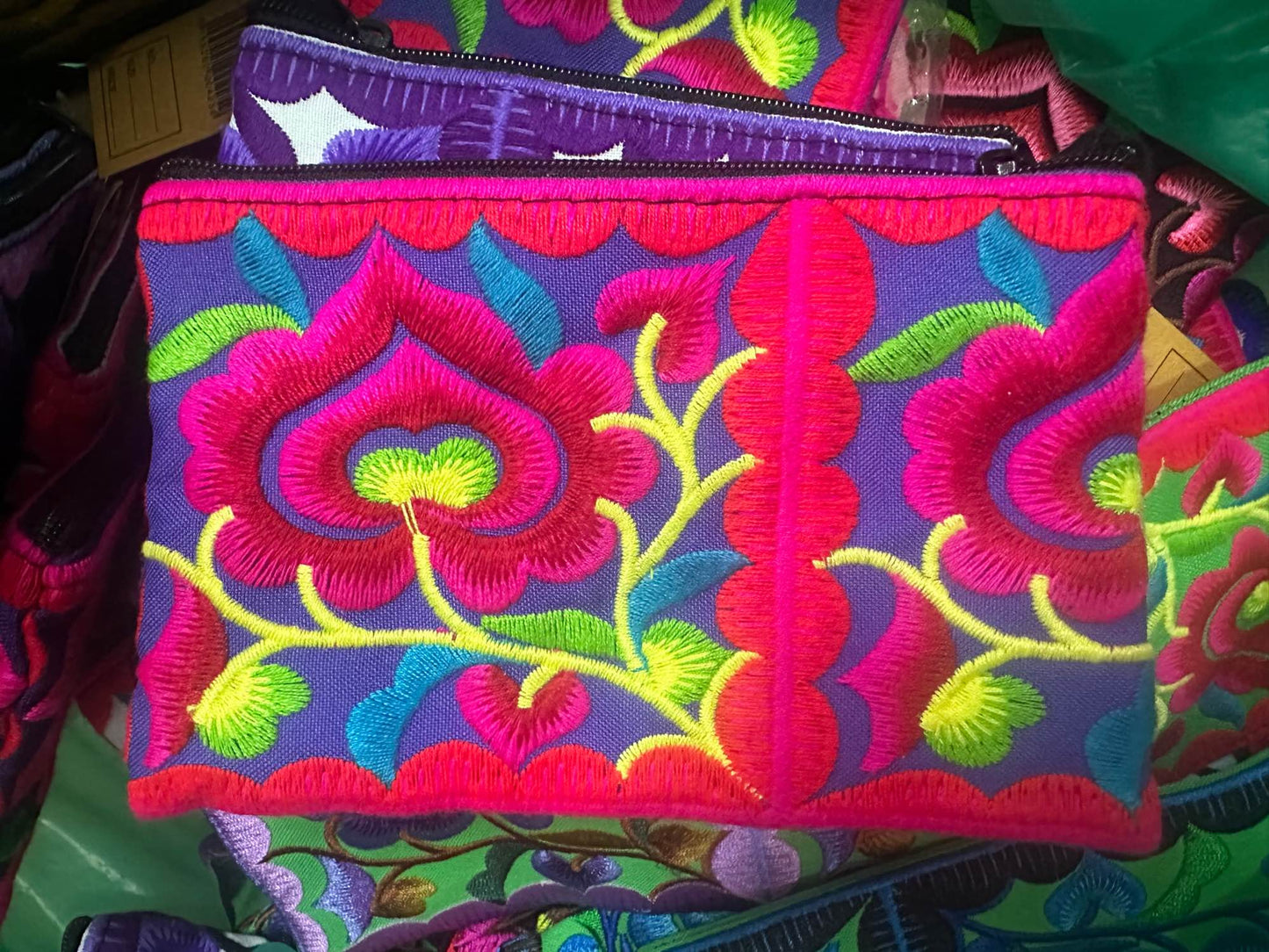 Hilltribe coin purse, embroidered, with designs on both sides. Has a wrist strap, zipper and lining. Size 4x5.5 inches.