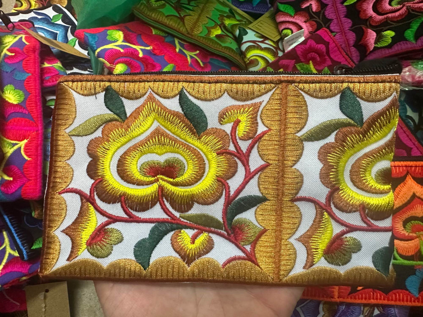 Hilltribe coin purse, embroidered, with designs on both sides. Has a wrist strap, zipper and lining. Size 4x5.5 inches.