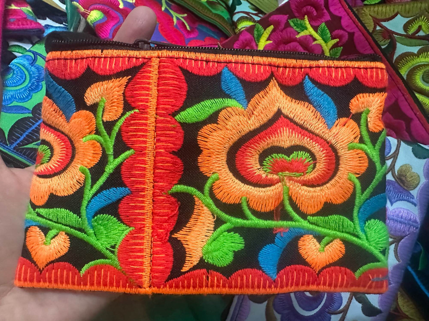 Hilltribe coin purse, embroidered, with designs on both sides. Has a wrist strap, zipper and lining. Size 4x5.5 inches.