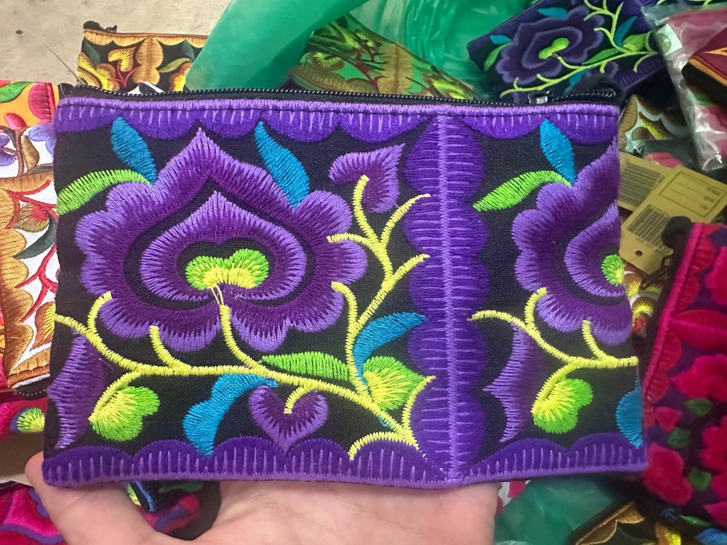 Hilltribe coin purse, embroidered, with designs on both sides. Has a wrist strap, zipper and lining. Size 4x5.5 inches.