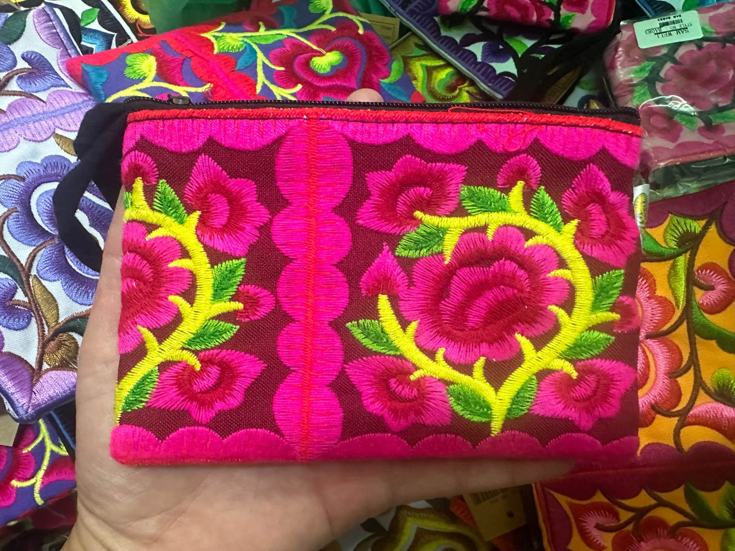 Hilltribe coin purse, embroidered, with designs on both sides. Has a wrist strap, zipper and lining. Size 4x5.5 inches.