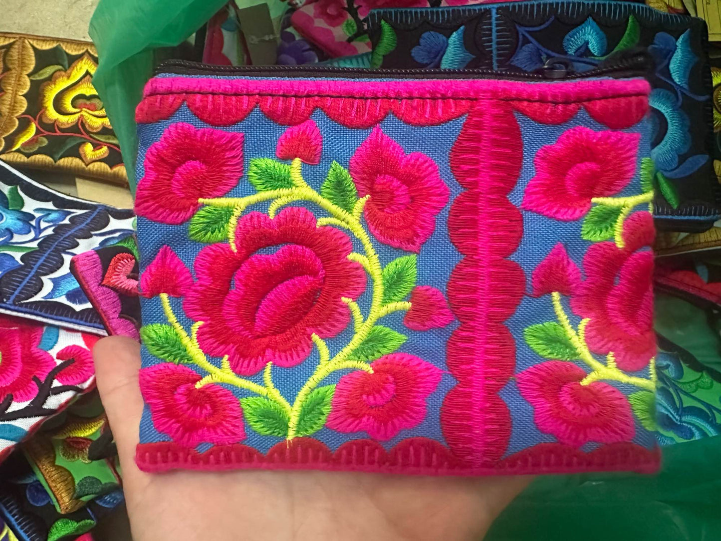 Hilltribe coin purse, embroidered, with designs on both sides. Has a wrist strap, zipper and lining. Size 4x5.5 inches.